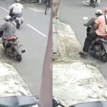 Hoch in den Armen! Mann klebt in Süd-Jakarta QR-Aufkleber für Online-Glücksspiele, die Polizei greift ein